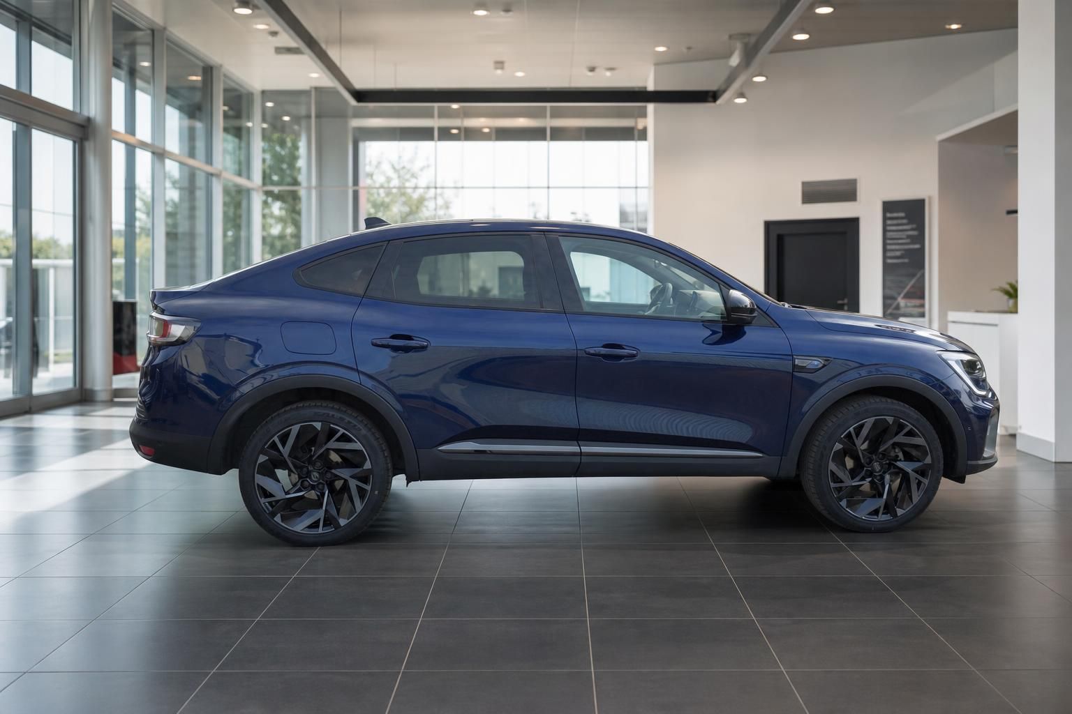 Renault SUV-Coupe blau metallic Seitenansicht mit schwarzen Alufelgen im Autohaus Showroom