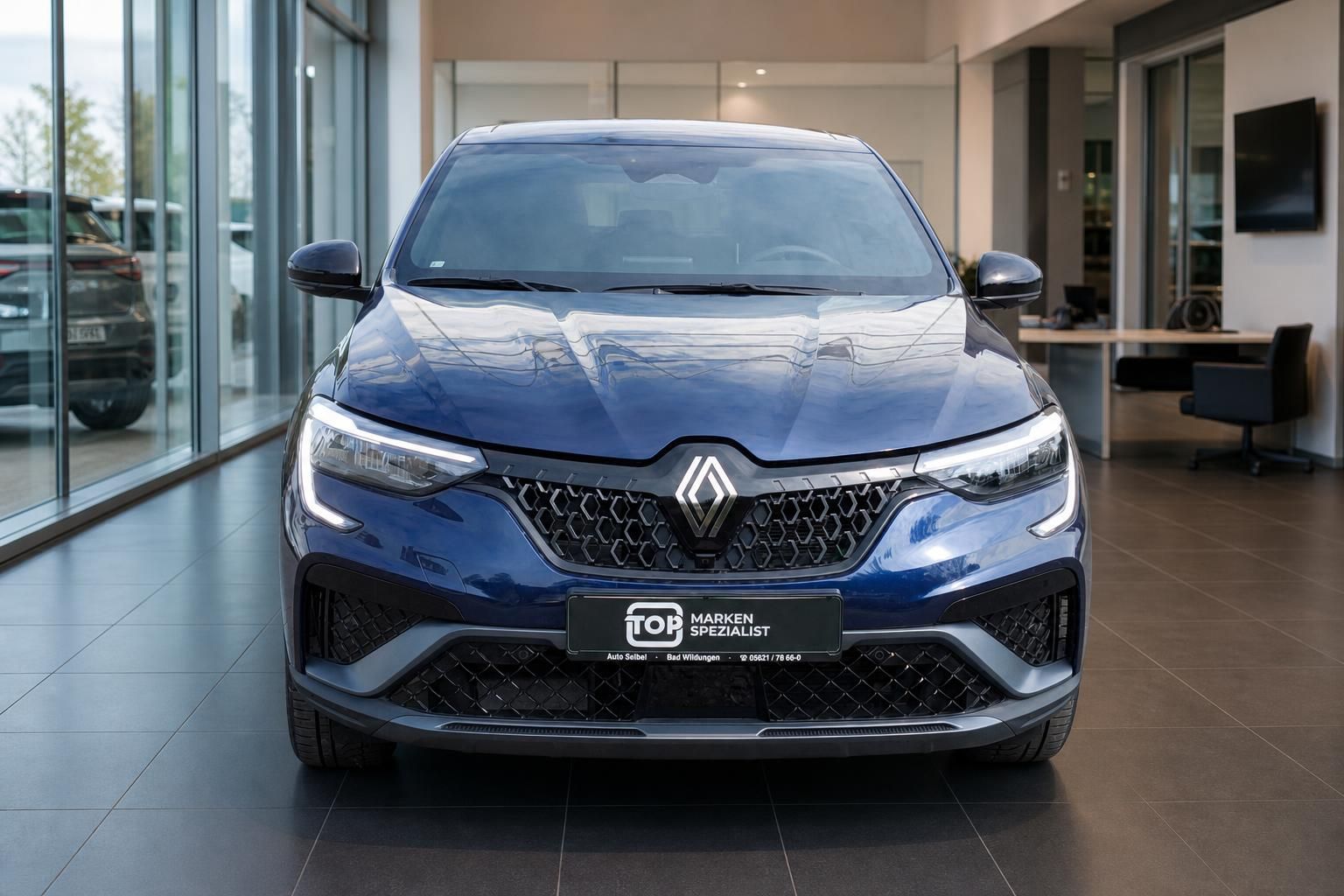 Renault SUV-Coupe blau metallic Frontansicht mit LED-Scheinwerfern im modernen Autohaus