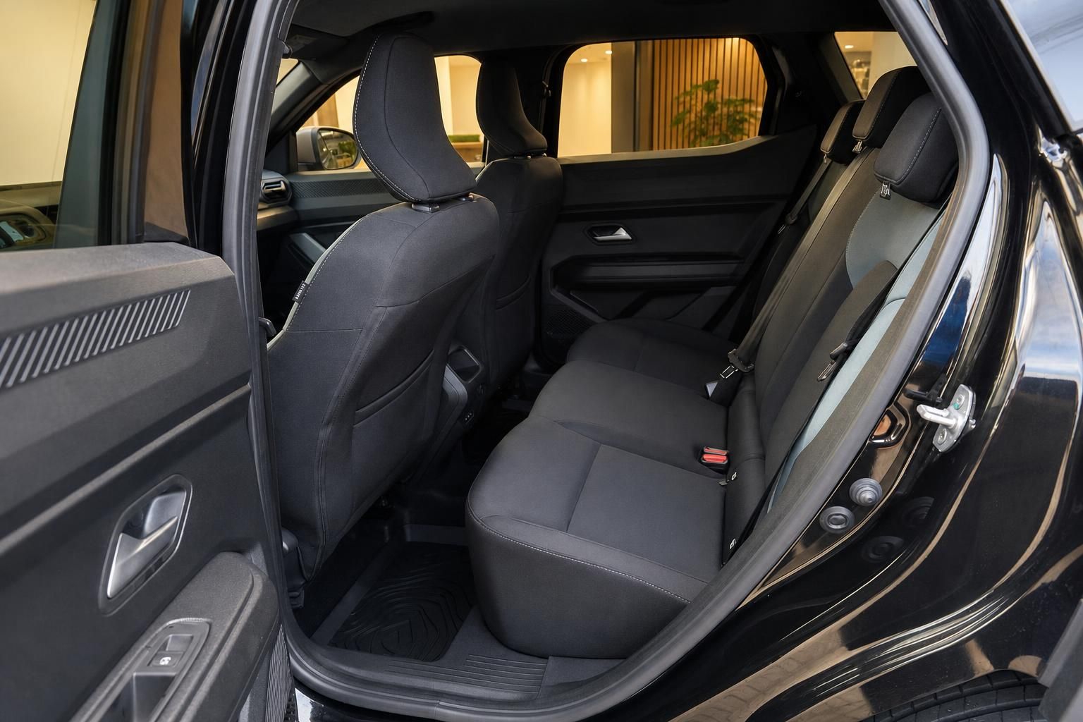 Fahrzeug-Rücksitzbereich mit schwarzen Sitzen und geöffneter Tür im Autohaus-Showroom