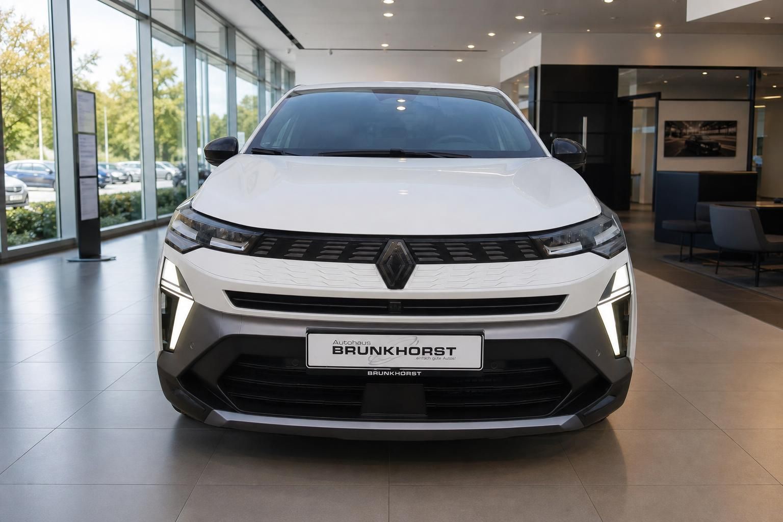 Weißer Renault Symbioz Frontansicht im Autohaus - modernes Elektrofahrzeug mit LED-Scheinwerfern