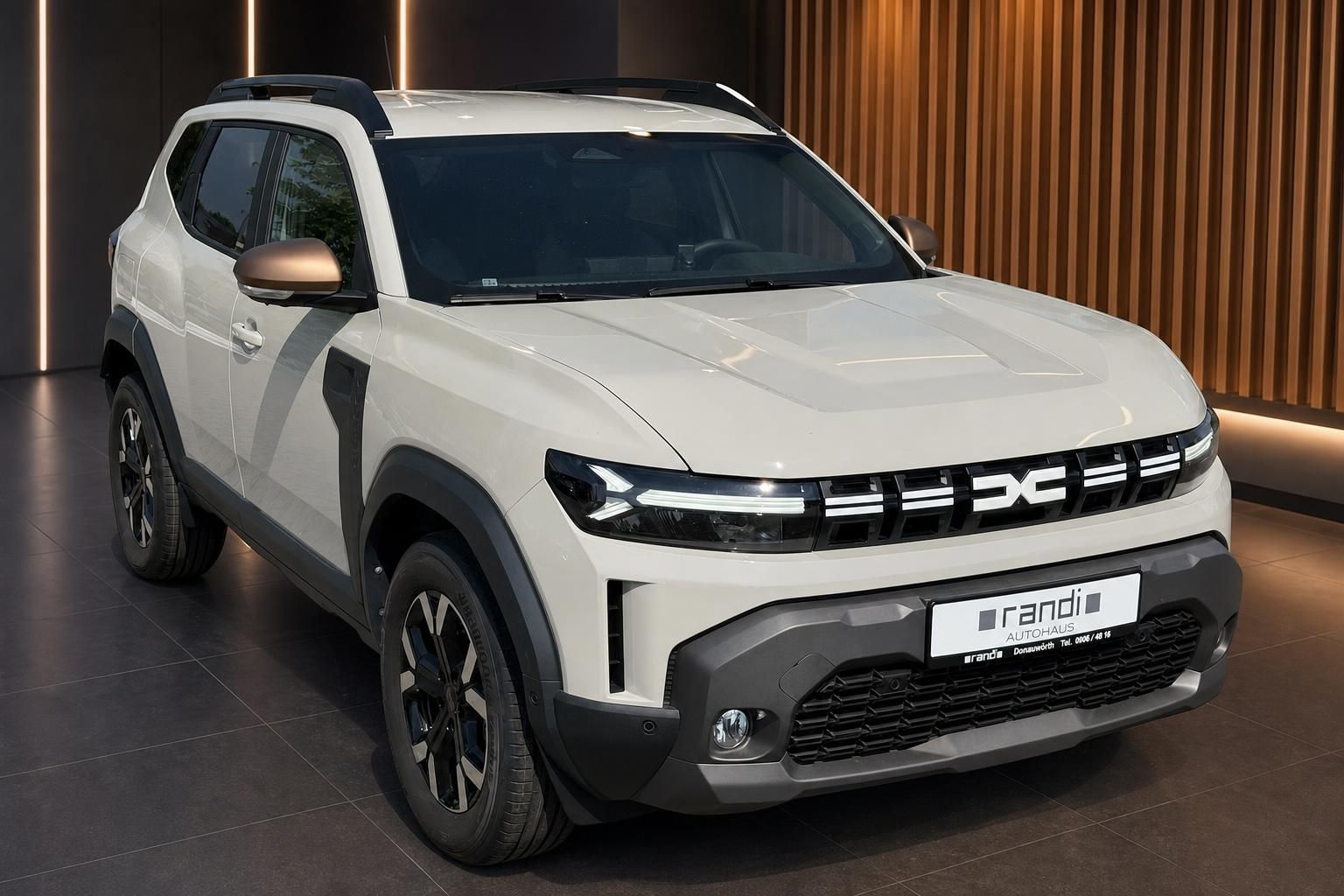 Dacia SUV weiß Seitenansicht schräg im Autohaus Randi Showroom