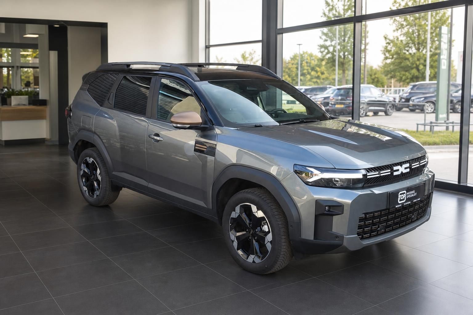 Dacia Bigster SUV grau, Frontansicht schraeg im Autohaus-Showroom
