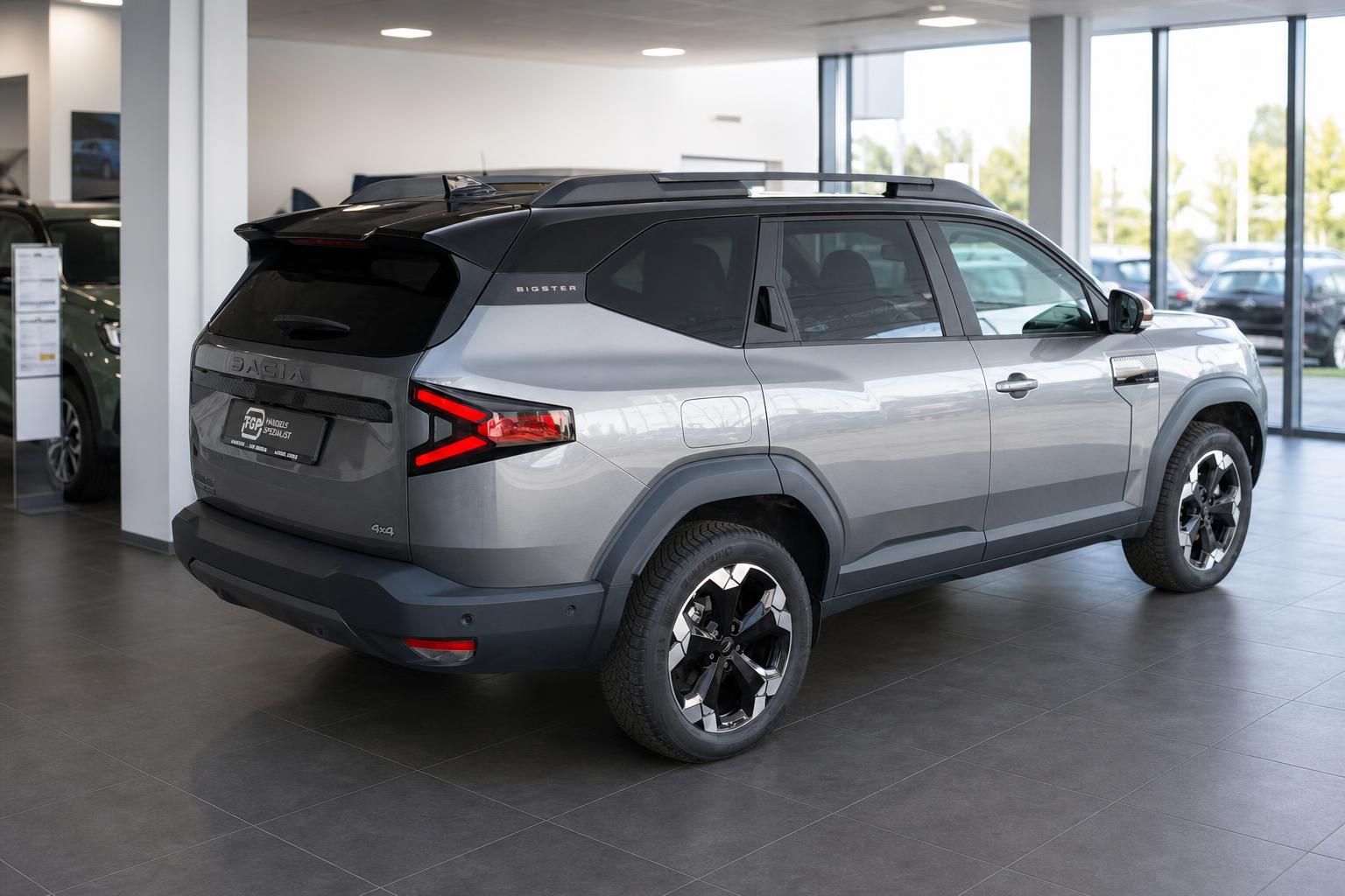 Dacia Bigster 4x4 grau Seitenansicht im Autohaus Showroom