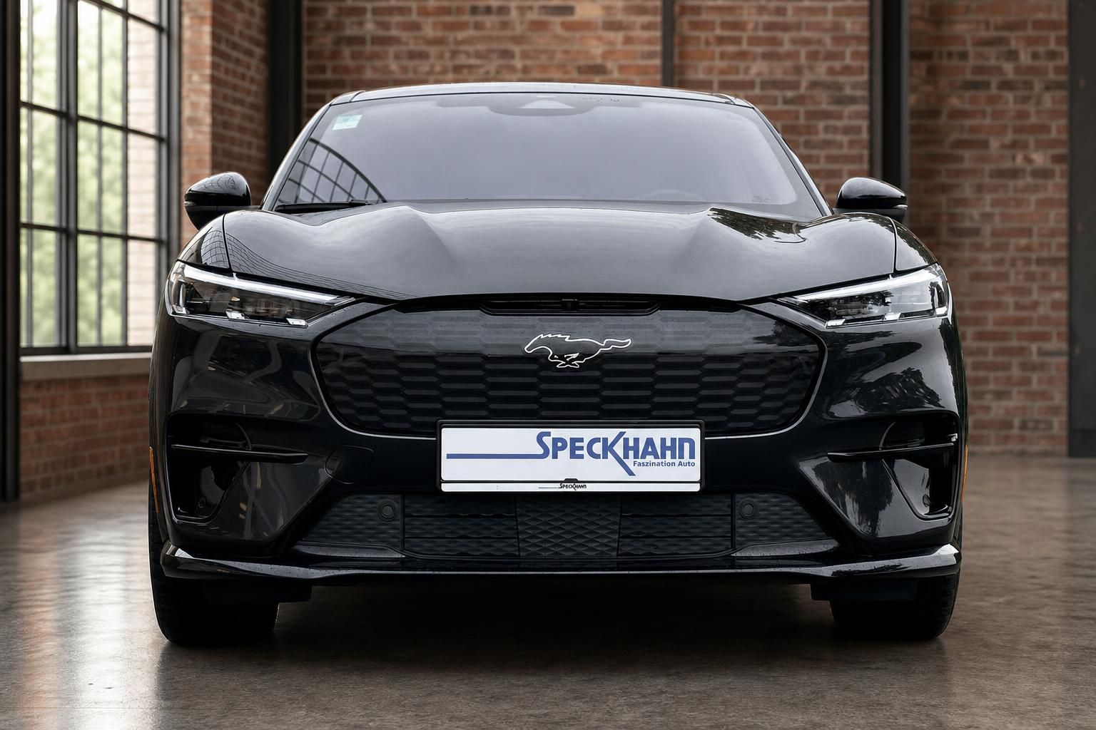 Ford Mustang Mach-E schwarz Frontansicht mit LED-Scheinwerfern in Halle