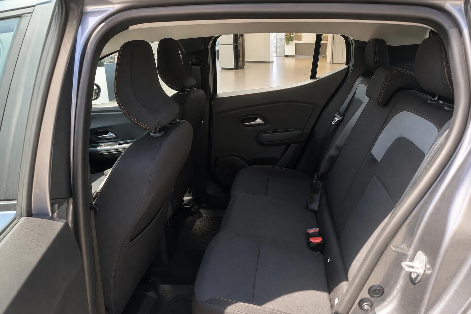 Dacia Rücksitzbank schwarz-grau mit Sicherheitsgurten, Blick durch geöffnete Hintertür