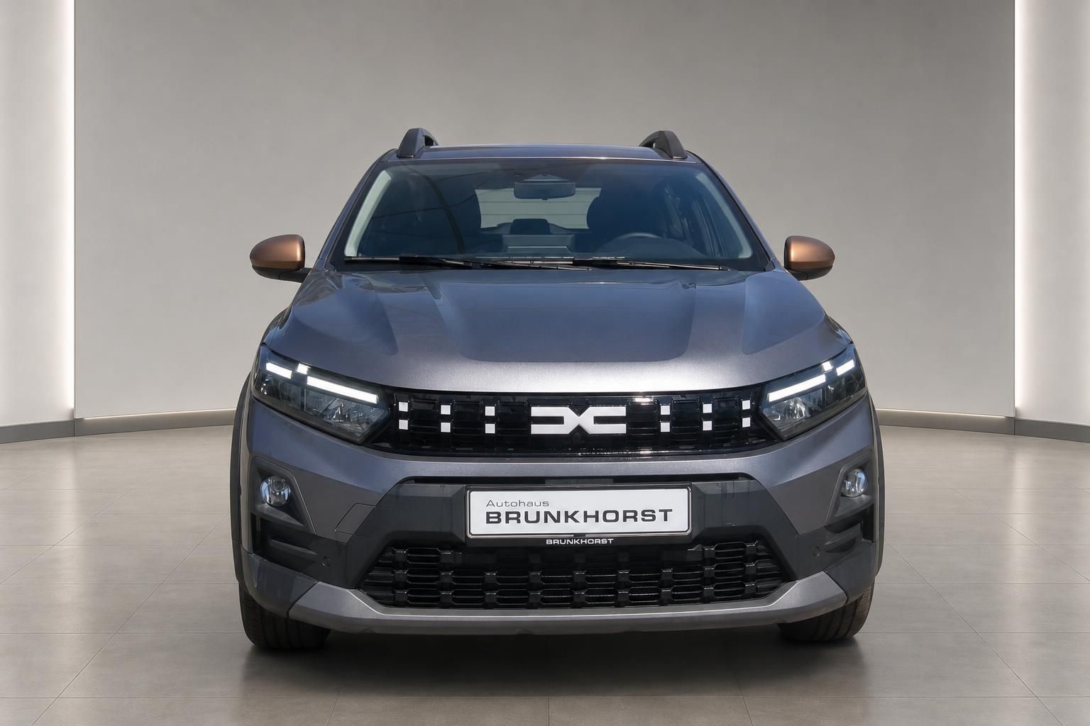 Dacia Sandero Stepway grau Frontansicht mit Dacia-Logo-Kühlergrill im Autohaus