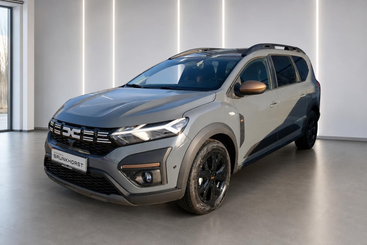 Dacia SUV grau metallic Frontansicht im Autohaus Showroom