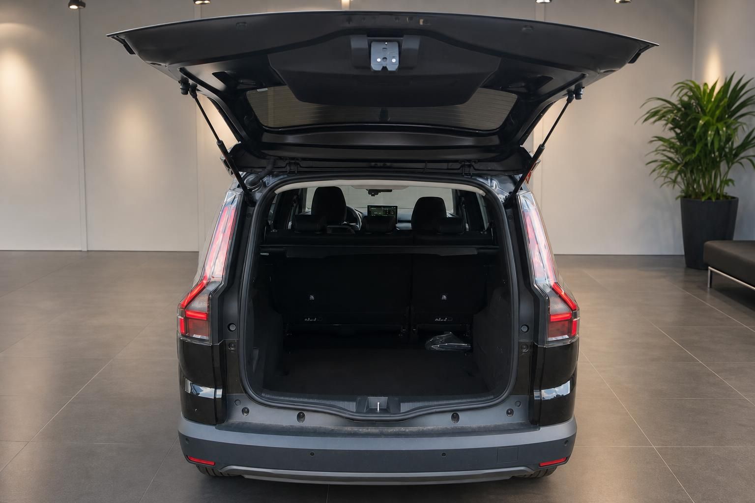 Kofferraum eines schwarzen SUV mit geoeffneter Heckklappe und umgeklappten Sitzen