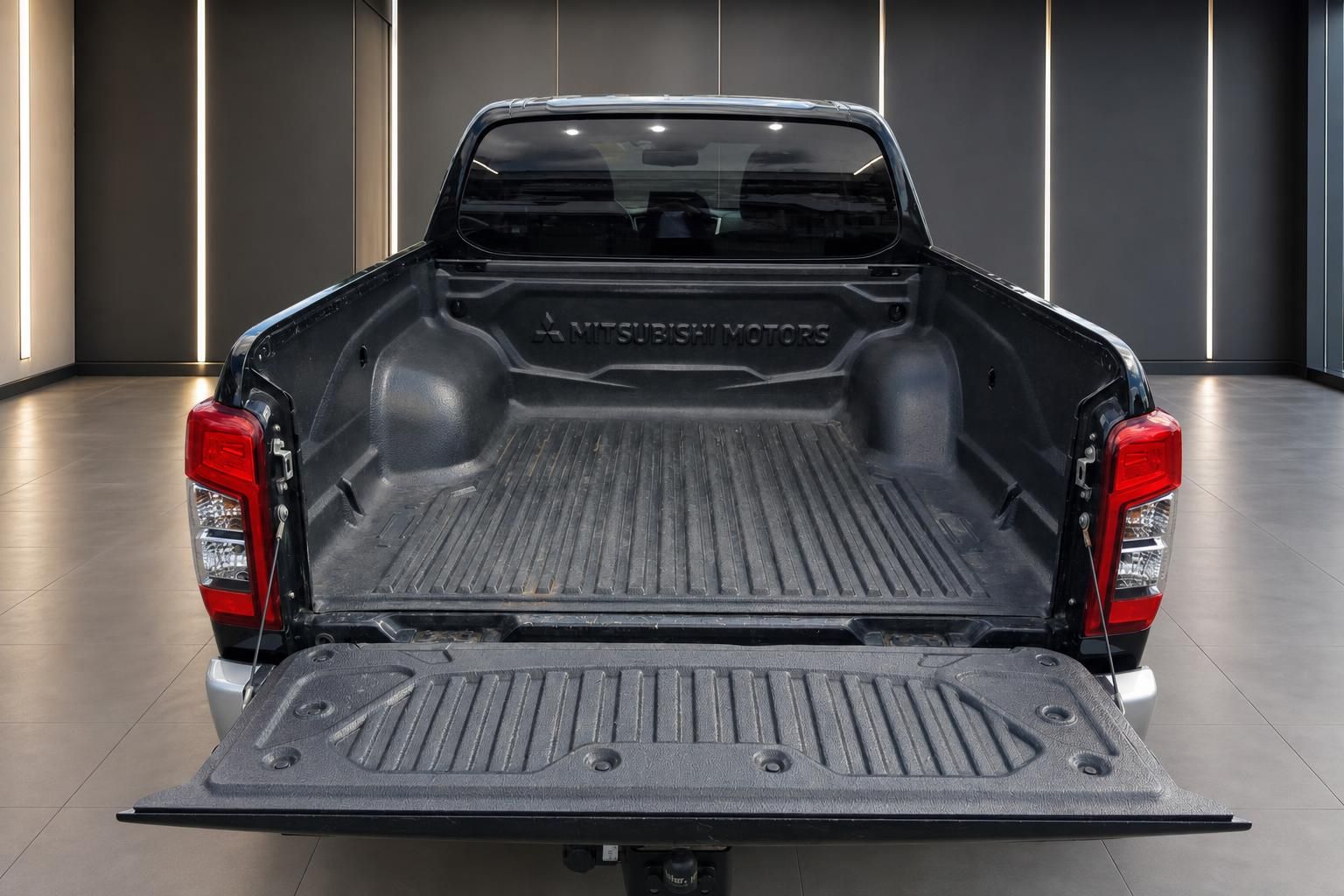 Mitsubishi Pickup Laderaum mit schwarzer Kunststoff-Auskleidung und geöffneter Heckklappe