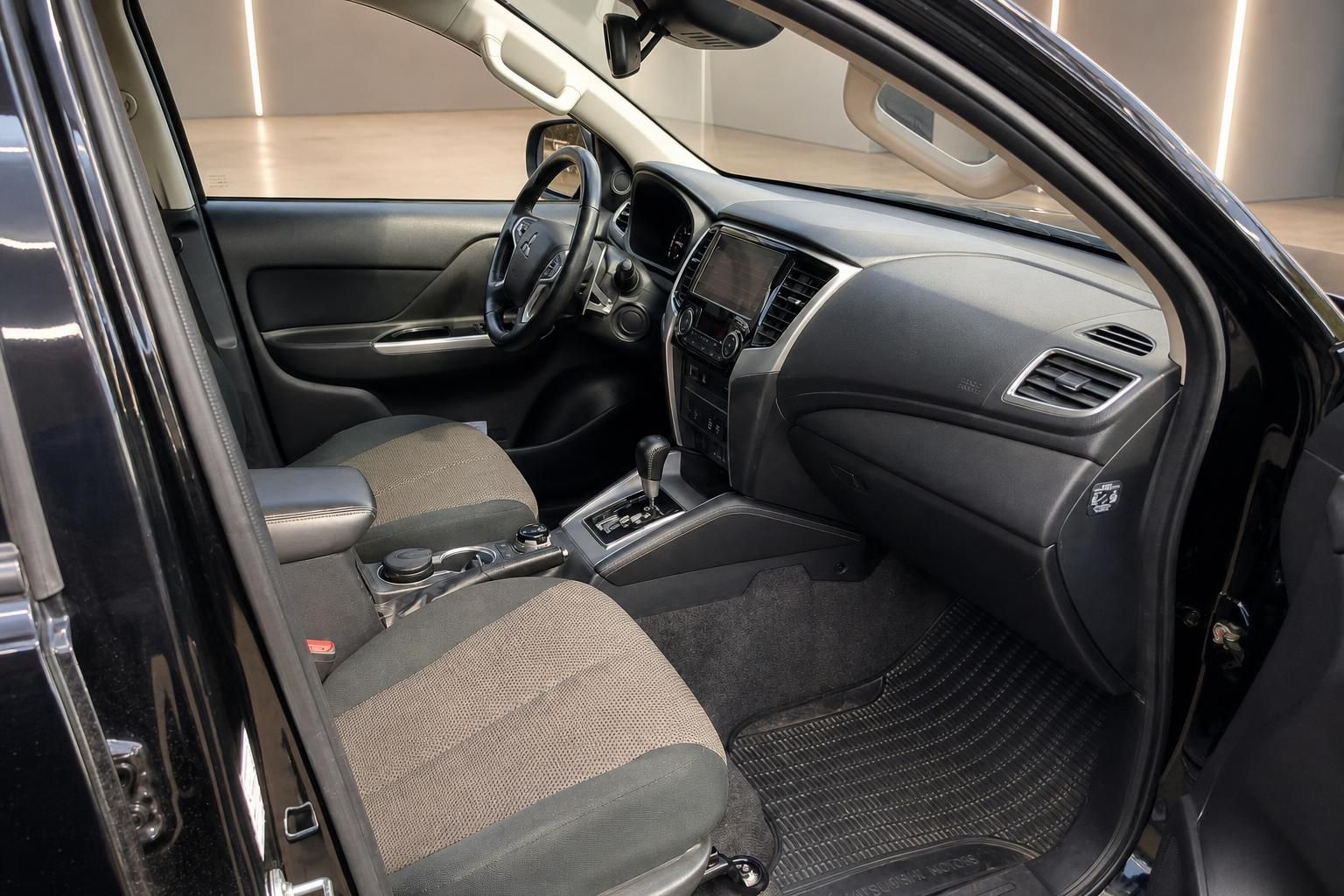 Mitsubishi Innenraum Beifahrerseite mit Armaturenbrett, Sitze und offener Tür