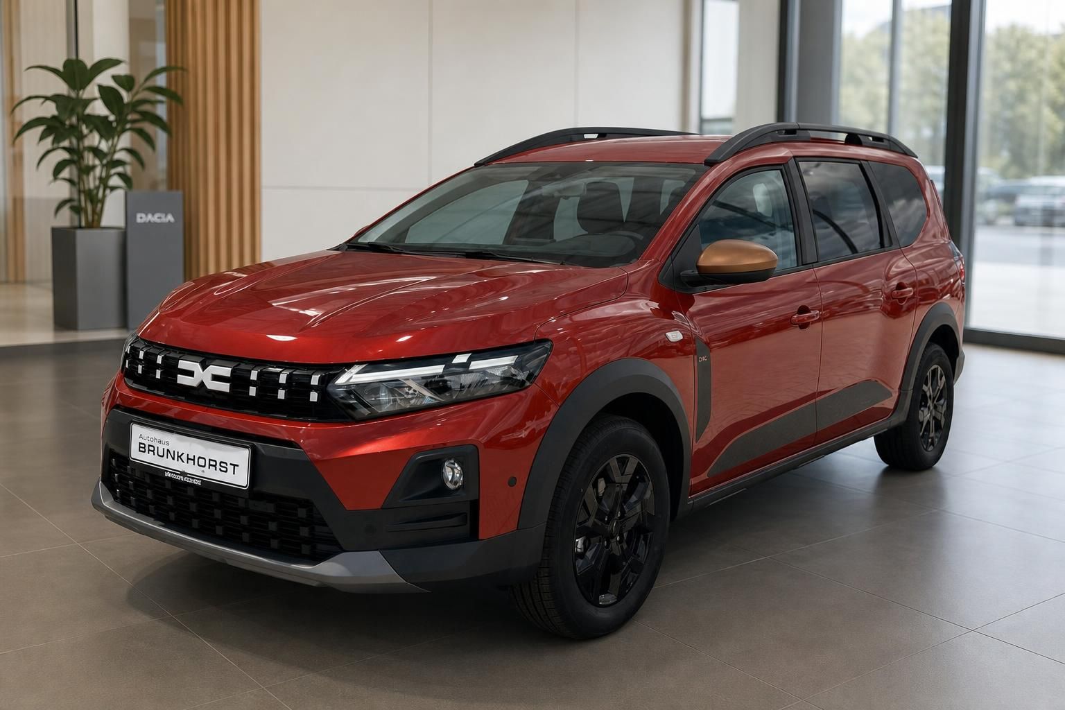 Roter Dacia SUV in modernem Autohaus Showroom - Dreiviertelansicht von vorne links