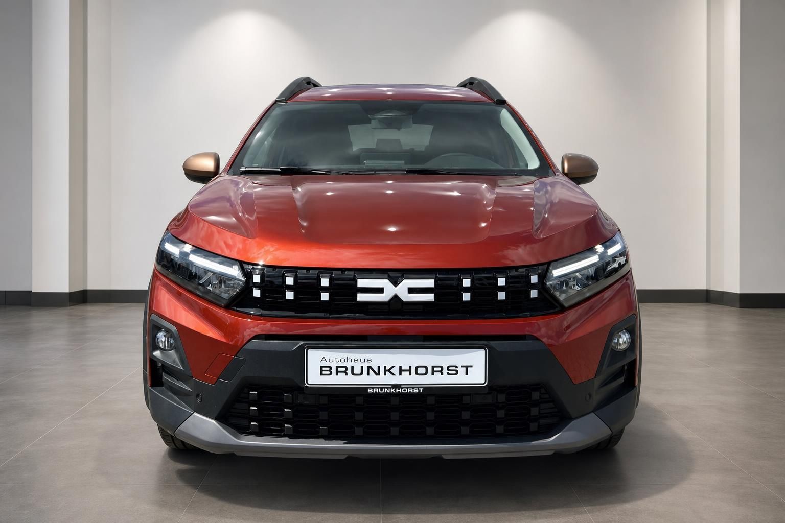 Roter Dacia SUV Frontansicht im Autohaus mit LED-Scheinwerfern und DC-Logo im Kühlergrill