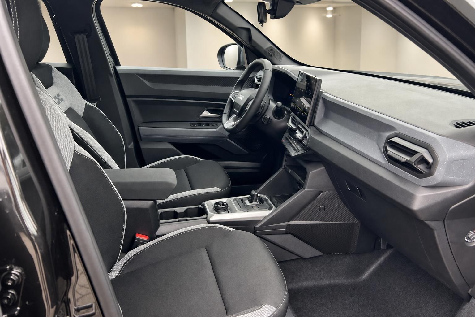 Dacia Innenraum Vordersitze mit Lenkrad, Mittelkonsole und Infotainment-Display