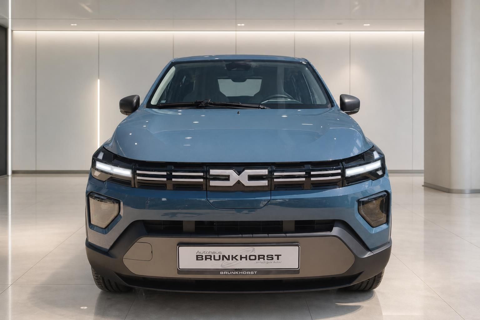 Dacia Spring Elektroauto blaue Frontansicht im Showroom