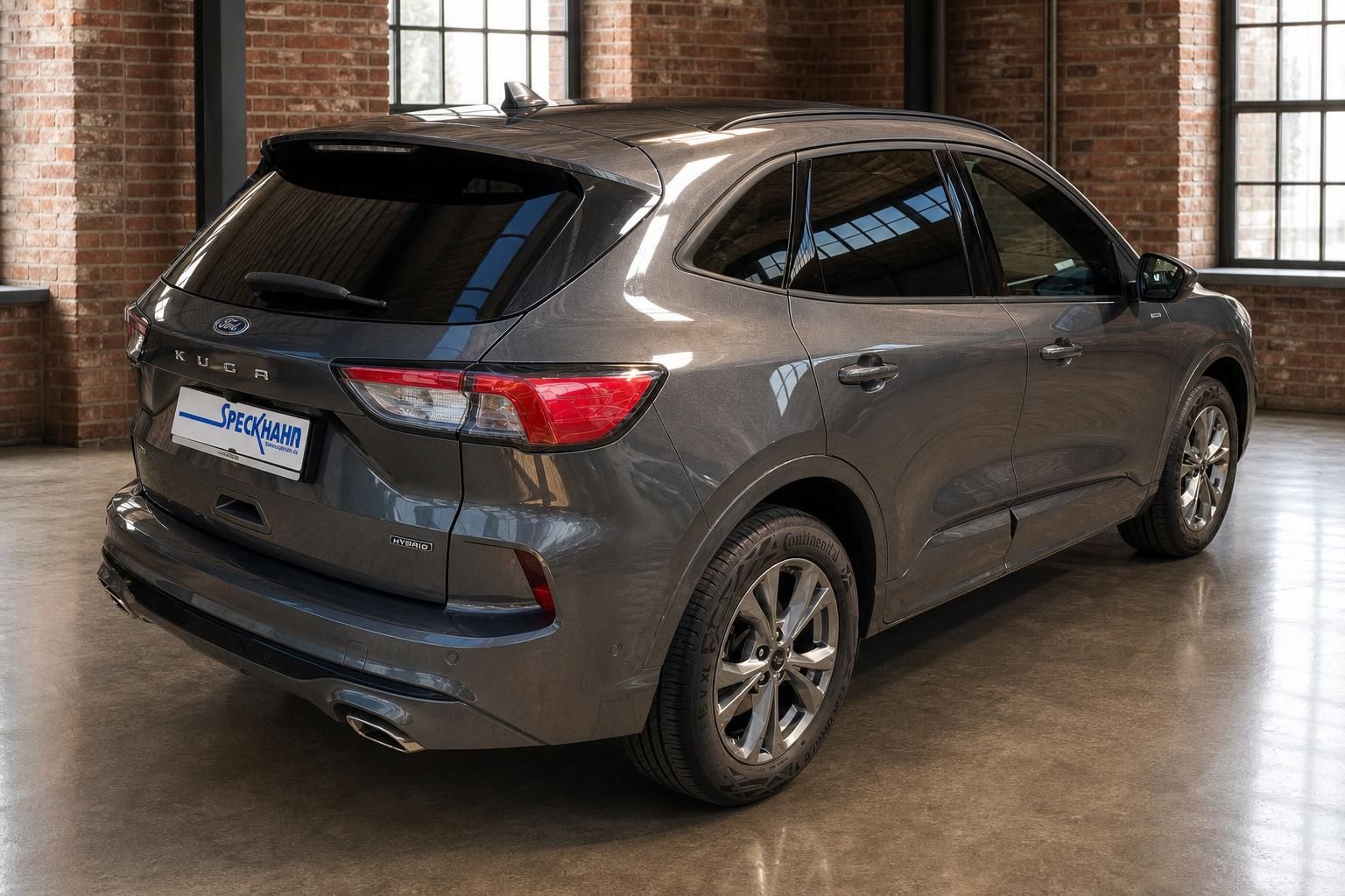 Ford Kuga Hybrid in Grau, Heck- und Seitenansicht mit Alufelgen