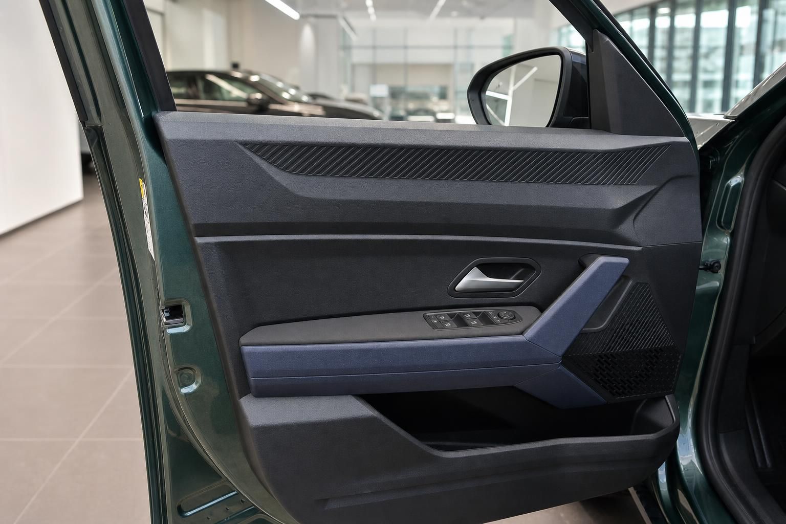 Dacia SUV grün Fahrertür geöffnet mit schwarzer Türverkleidung und blauen Akzenten