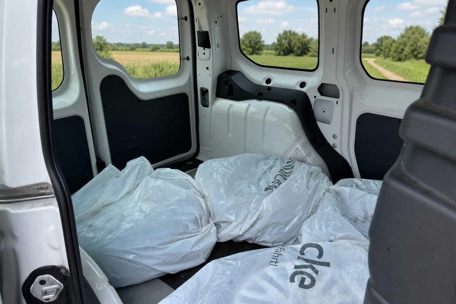 Laderaum eines Fahrzeugs mit verpackten Sitzen und Blick durchs Fenster
