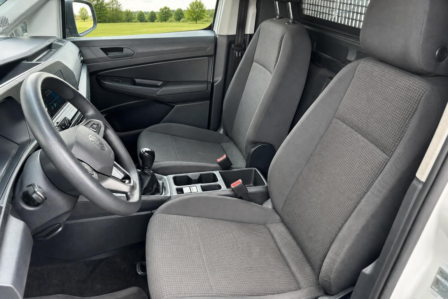 Fahrzeuginnenraum mit grauen Stoffsitzen und Lenkrad - Blick ins Cockpit
