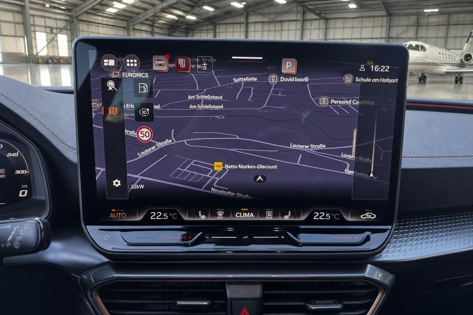 Modernes Infotainment-Display im Fahrzeug-Cockpit mit Navigationssystem und Klimasteuerung