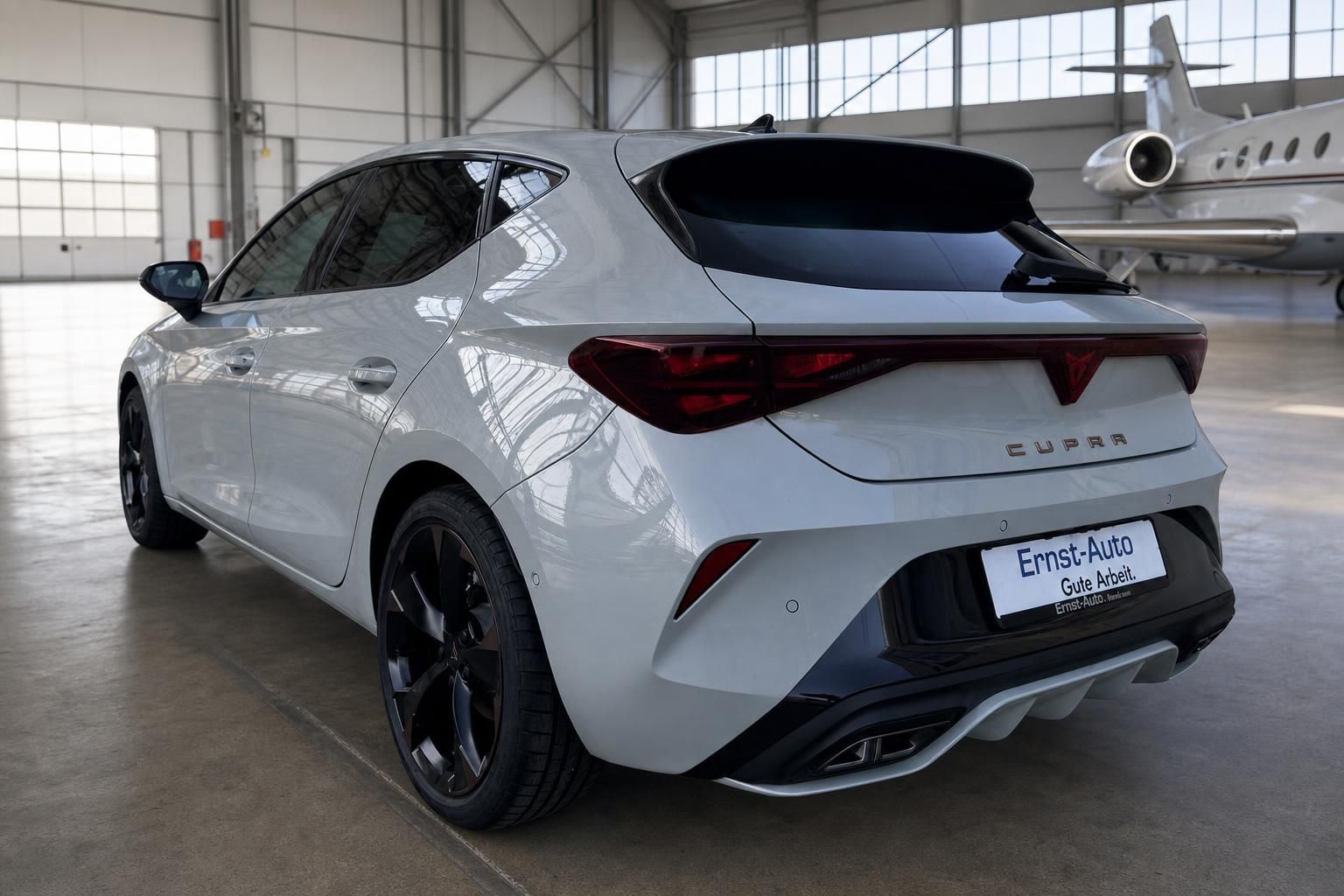 SEAT Cupra Leon Heckansicht in weiß mit Sportauspuff und schwarzen Felgen im Autohaus