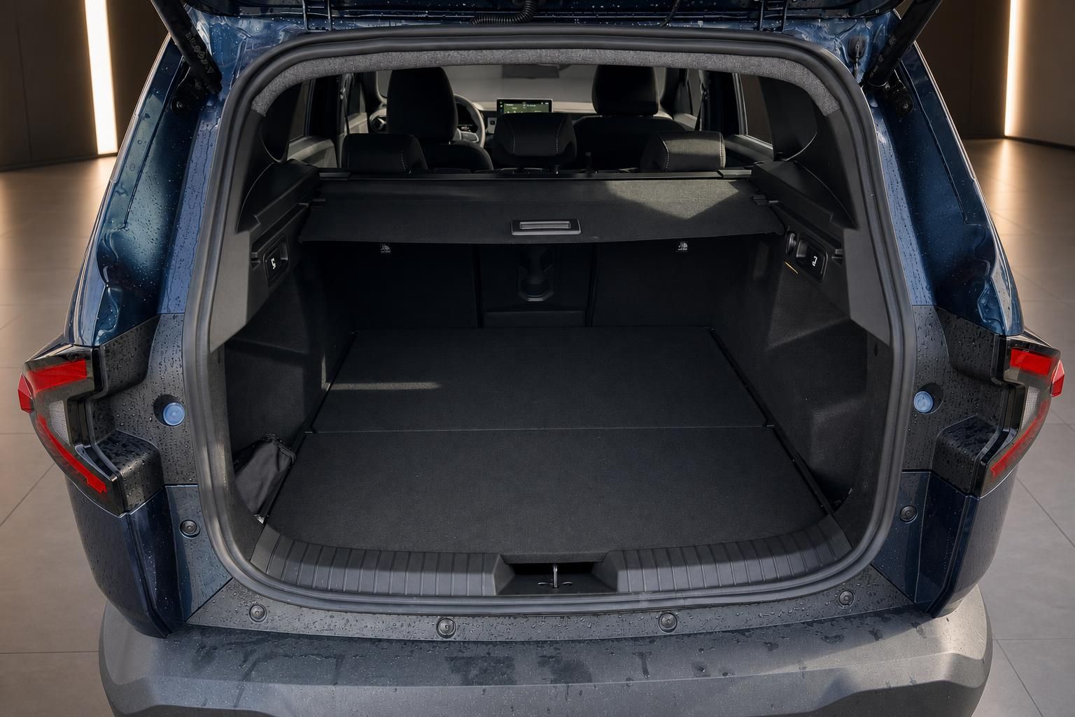 Großer Kofferraum eines blauen SUVs mit umgeklappten Rücksitzen und Ladeabdeckung