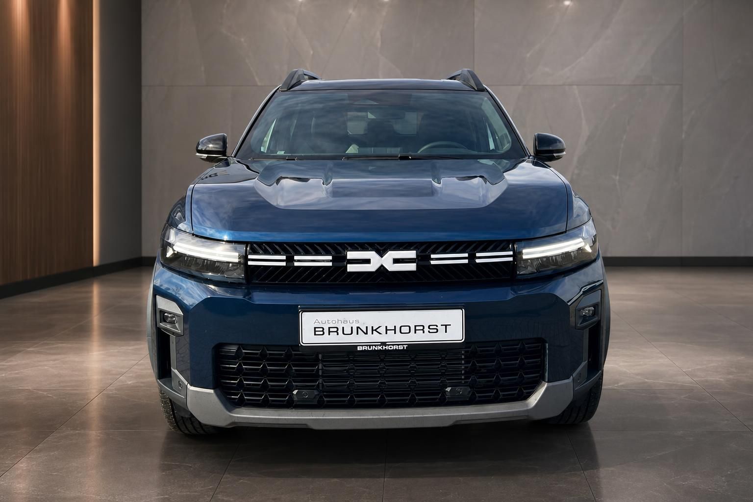 Dacia SUV Frontansicht in blau - LED-Scheinwerfer und charakteristischer Kühlergrill