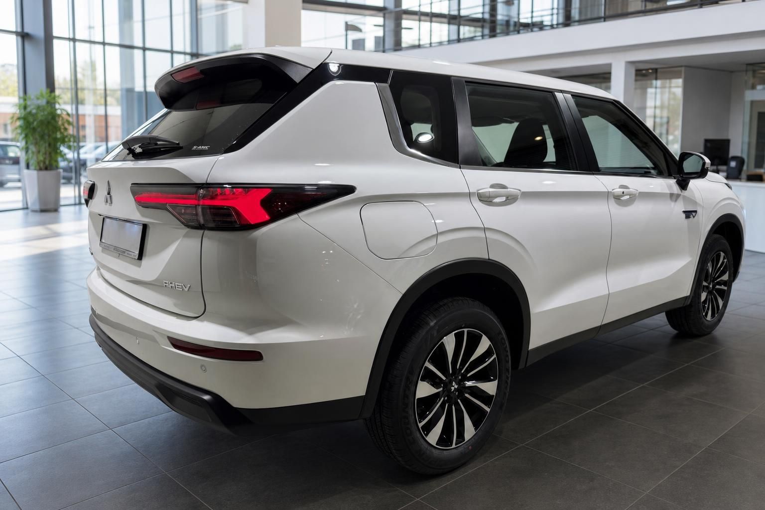 Mitsubishi Outlander PHEV weiß, seitliche Heckansicht im Showroom