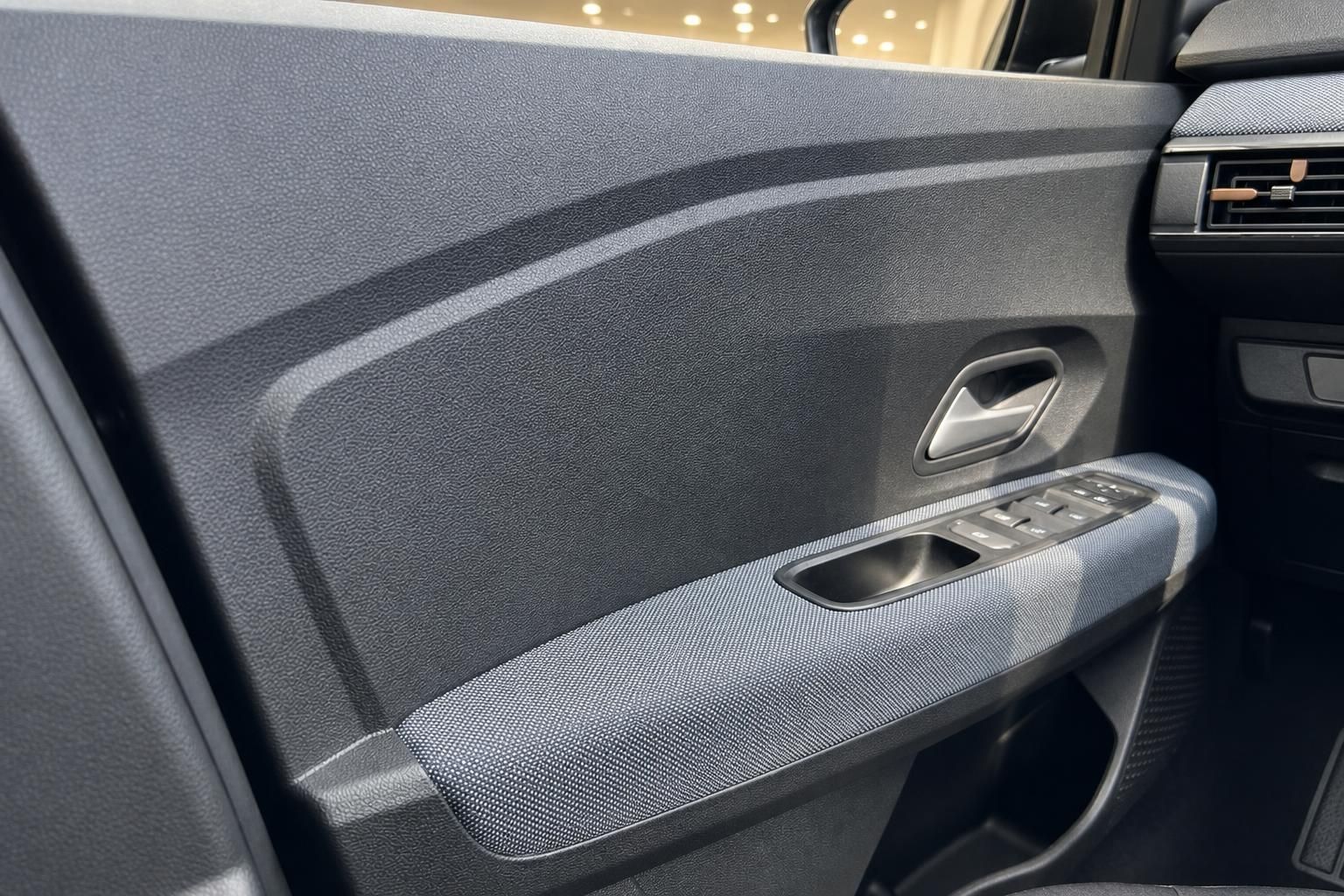 Detailansicht Tuerverkleidung mit Fensterheber im Fahrzeuginnenraum