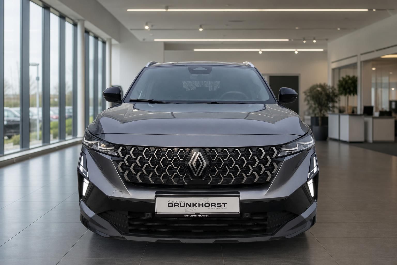 Renault Austral SUV Frontansicht in grau, markanter Kühlergrill und LED-Scheinwerfer im Autohaus
