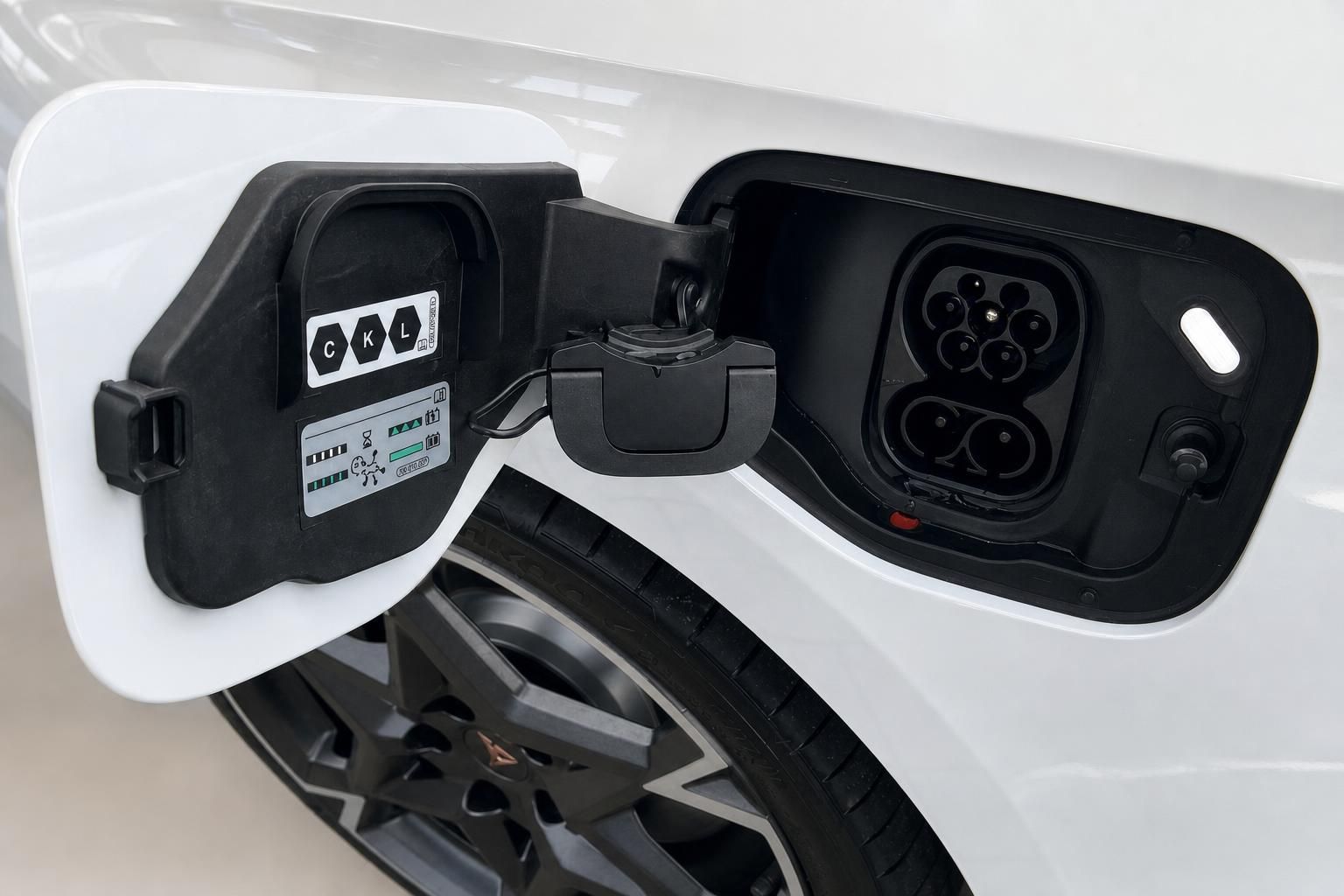 Ladeanschluss und Tankdeckel eines weissen Elektrofahrzeugs im Detail