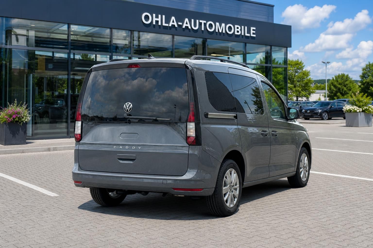 VW Caddy grau Heckansicht mit Kofferraum vor Autohaus
