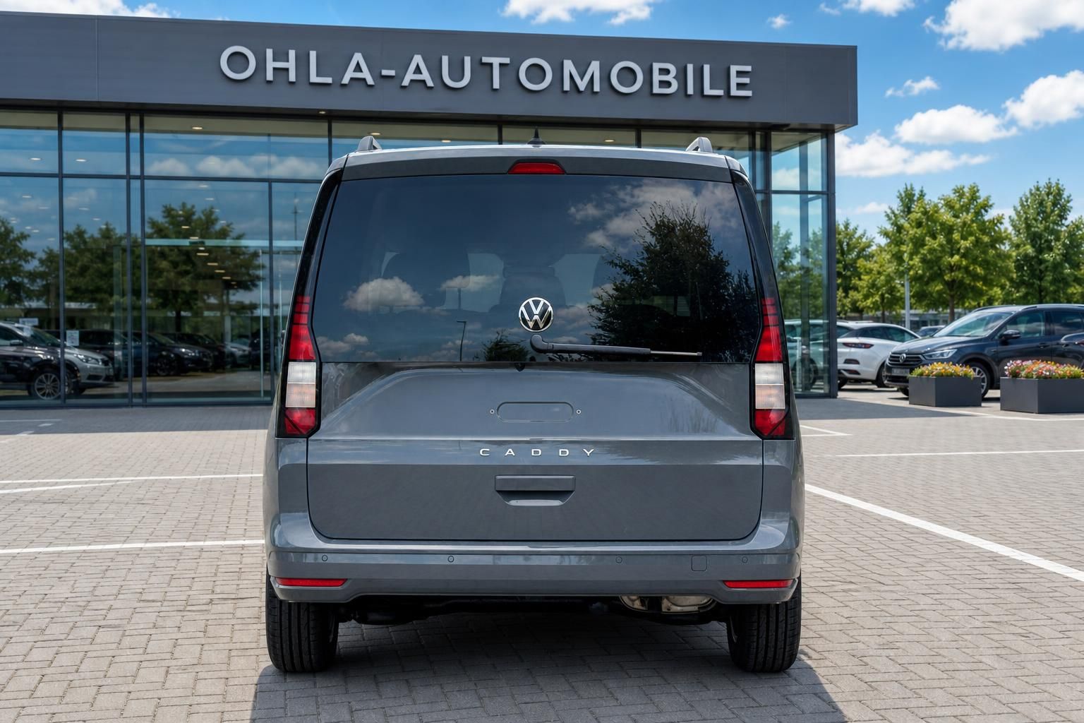 VW Caddy grau direkte Heckansicht vor Volkswagen Haendler
