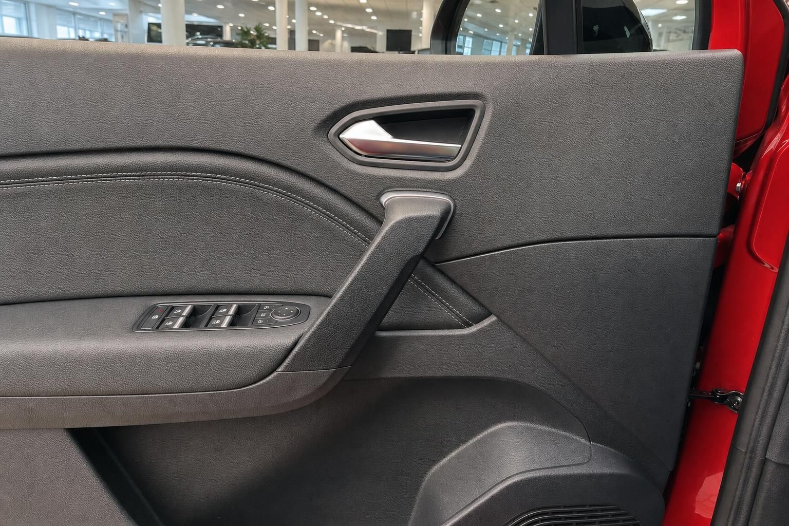 Tuerverkleidung mit Fensterheberschaltern im Innenraum eines roten Fahrzeugs