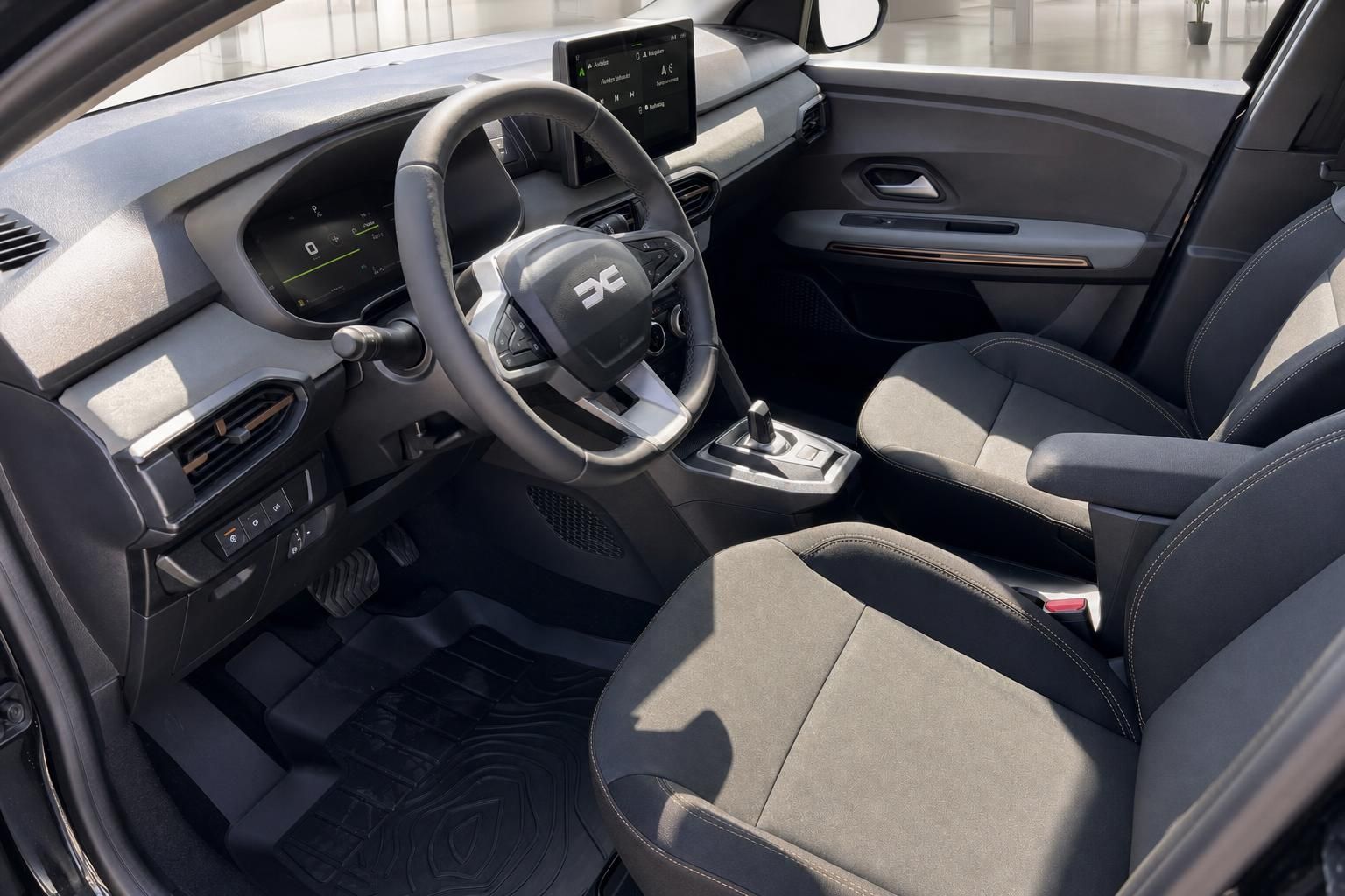 Dacia Jogger Innenraum mit Lenkrad, Touchscreen und grauen Sitzen mit modernem Design