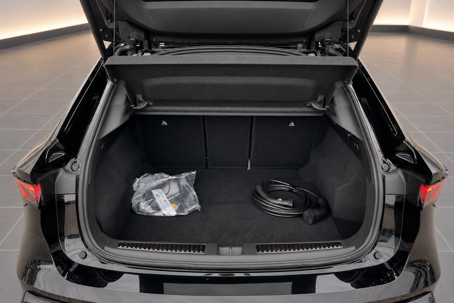 Geräumiger Kofferraum eines schwarzen Hybrid-SUV mit Ladekabel und Zubehör