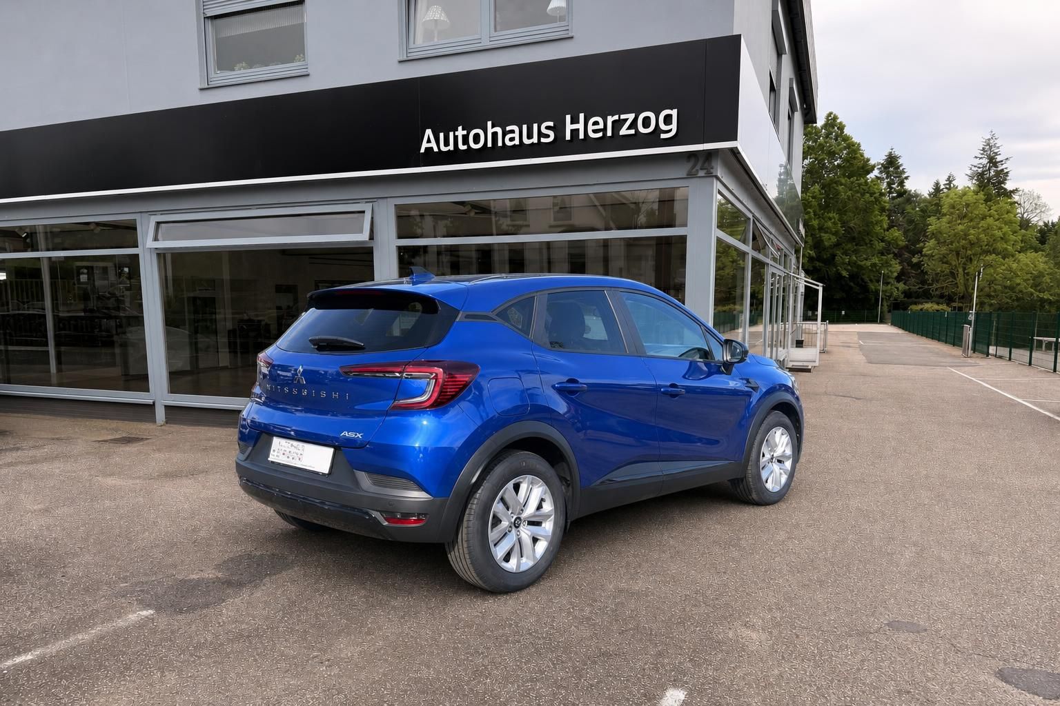 Blauer Mitsubishi ASX Kompakt-SUV Heckansicht mit schwarzen Kunststoffverkleidungen bei Autohaus Herzog