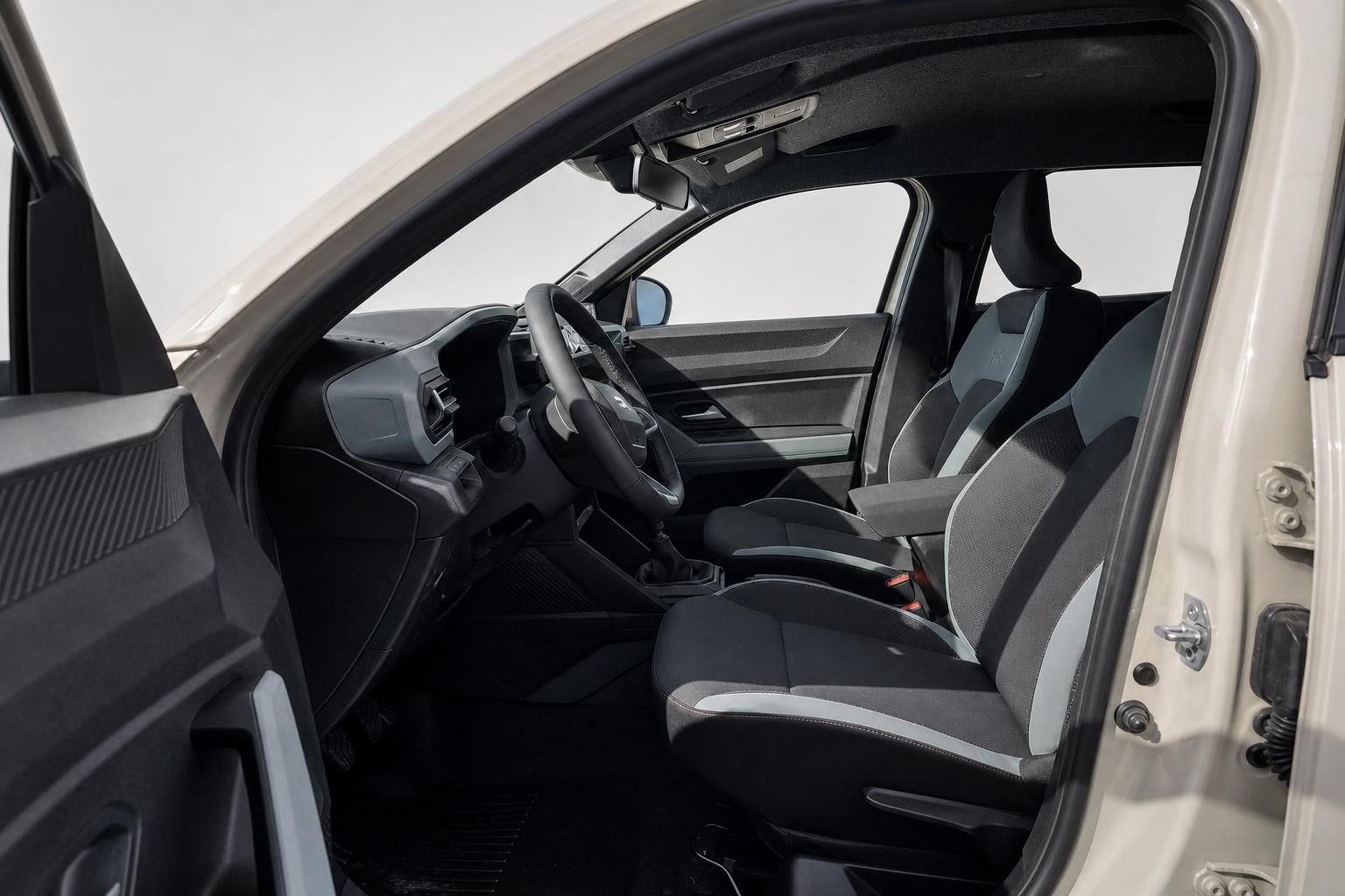 Dacia Duster Innenraum mit Vordersitzen und Cockpit bei geoeffneter Tuer
