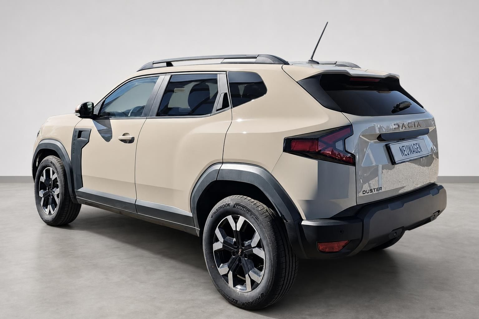 Dacia Duster Neuwagen beige Heckansicht schräg im Studio