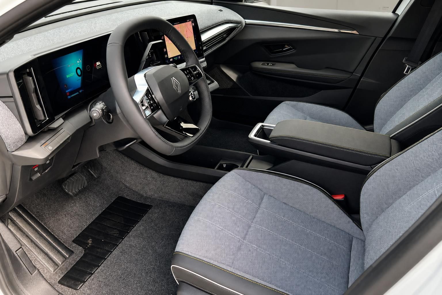 Renault Megane E-Tech Innenraum Fahrersitz mit blauem Stoffbezug und Lenkrad