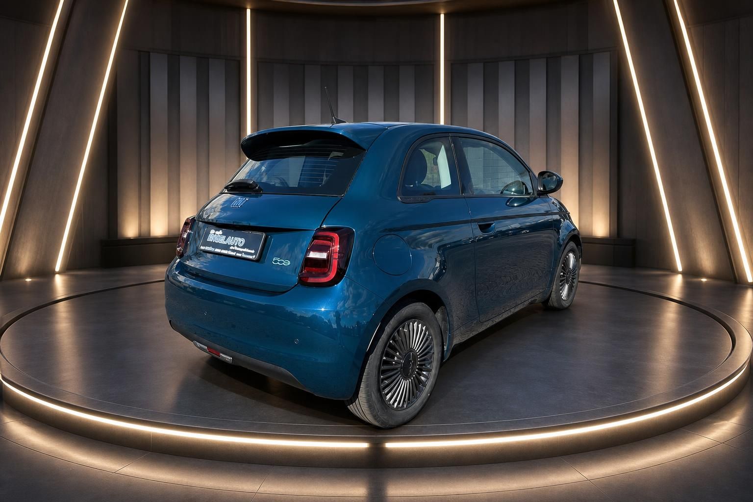 Blauer Fiat 500 Elektro von hinten auf Drehbühne im Showroom