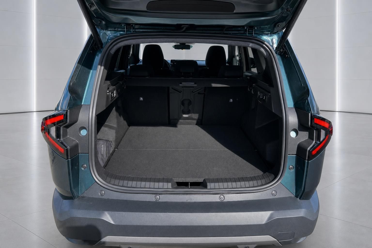 Geöffneter Kofferraum eines blauen SUV mit umgeklappten Rücksitzen und großem Laderaum