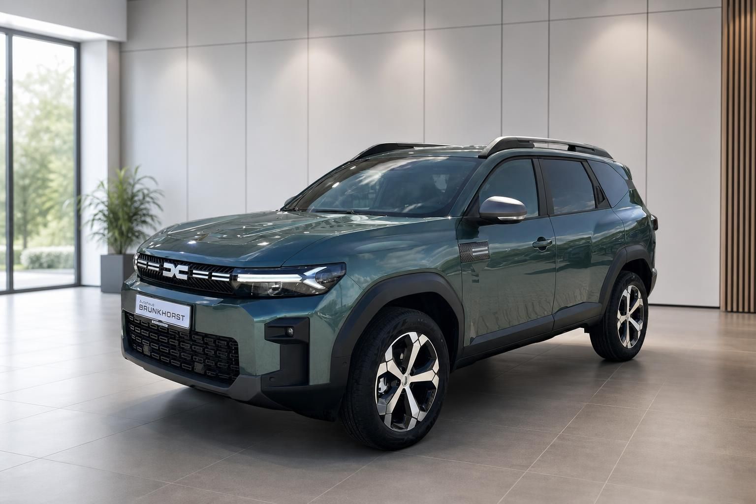 Dacia Bigster SUV seitliche Dreiviertelansicht in grün-grauer Lackierung im Autohaus Showroom