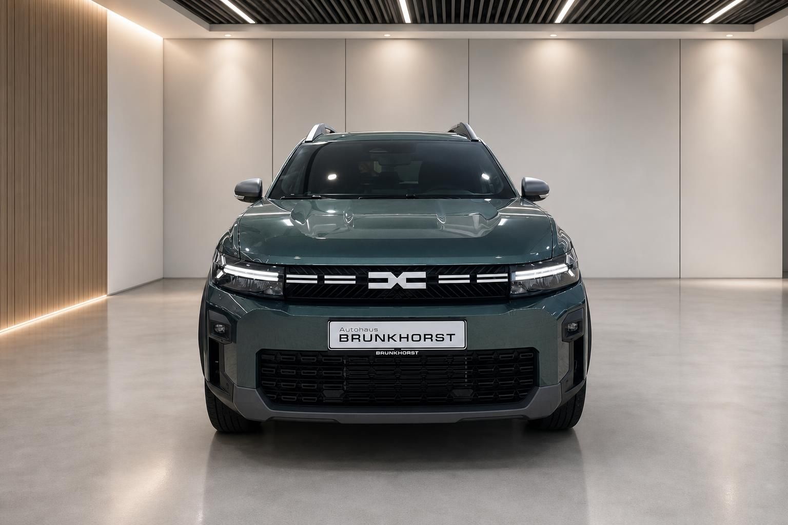Dacia Bigster SUV Frontansicht in grün-grauer Lackierung im Autohaus Brunkhorst Showroom
