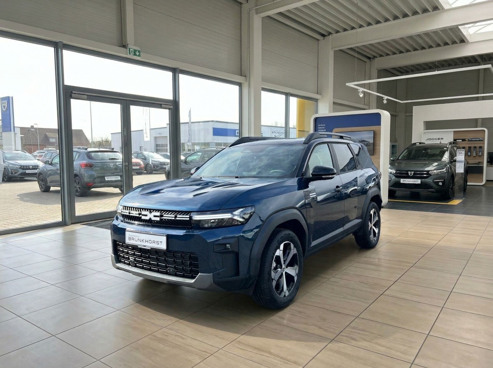 Dacia Bigster Hybrid SUV blau im Autohaus Showroom - Seitenansicht