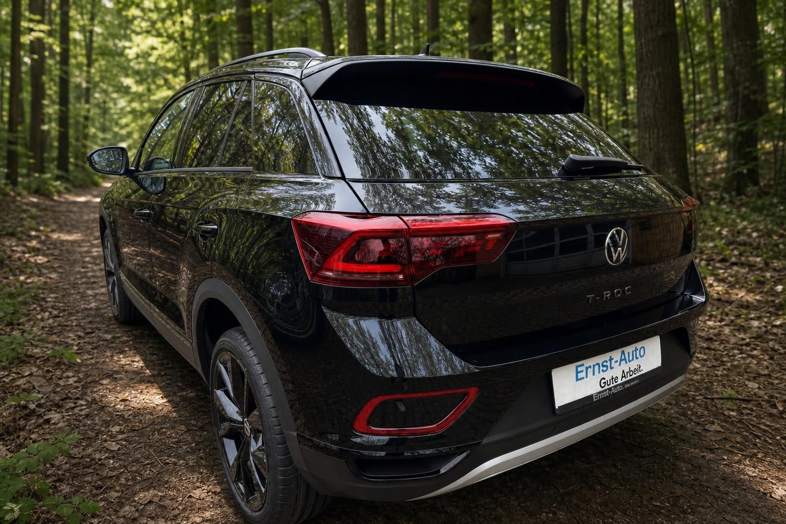 Volkswagen T-Roc schwarz Heckansicht mit LED-Rückleuchten im Wald bei Ernst-Auto