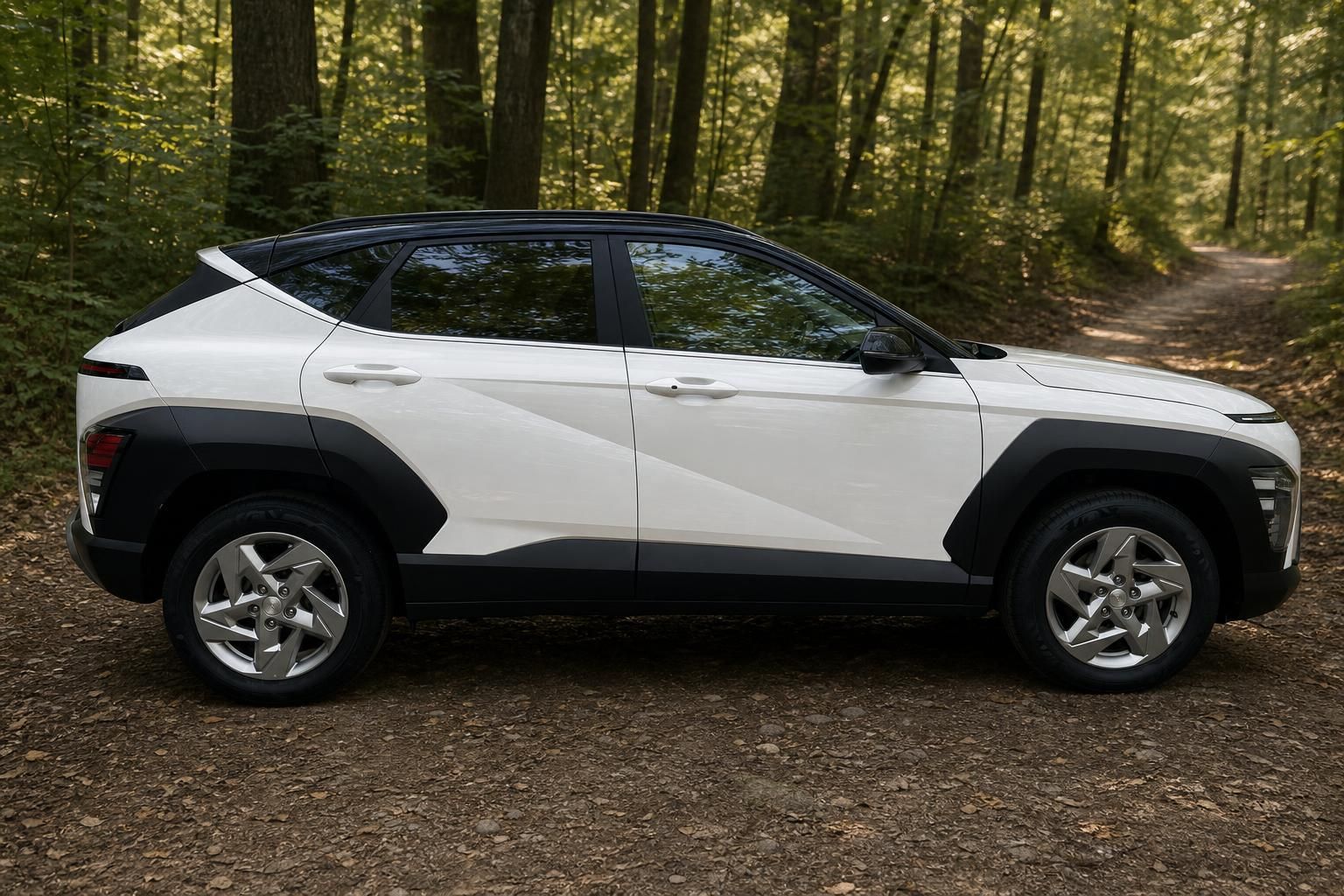 Weißer Hyundai Kona Elektro SUV Seitenansicht im Wald mit schwarzen Kunststoffverkleidungen