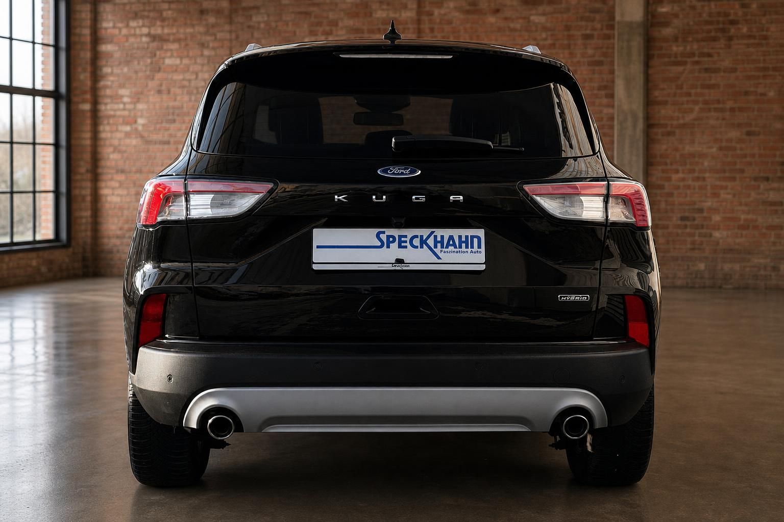 Ford Kuga Hybrid schwarz, direkte Heckansicht mit Rueckleuchten im Showroom