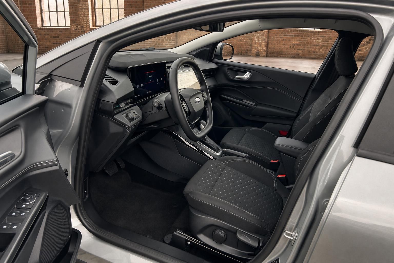 Ford Puma Innenraum – Fahrersitz, Lenkrad mit Ford-Logo und Touchscreen-Infotainment
