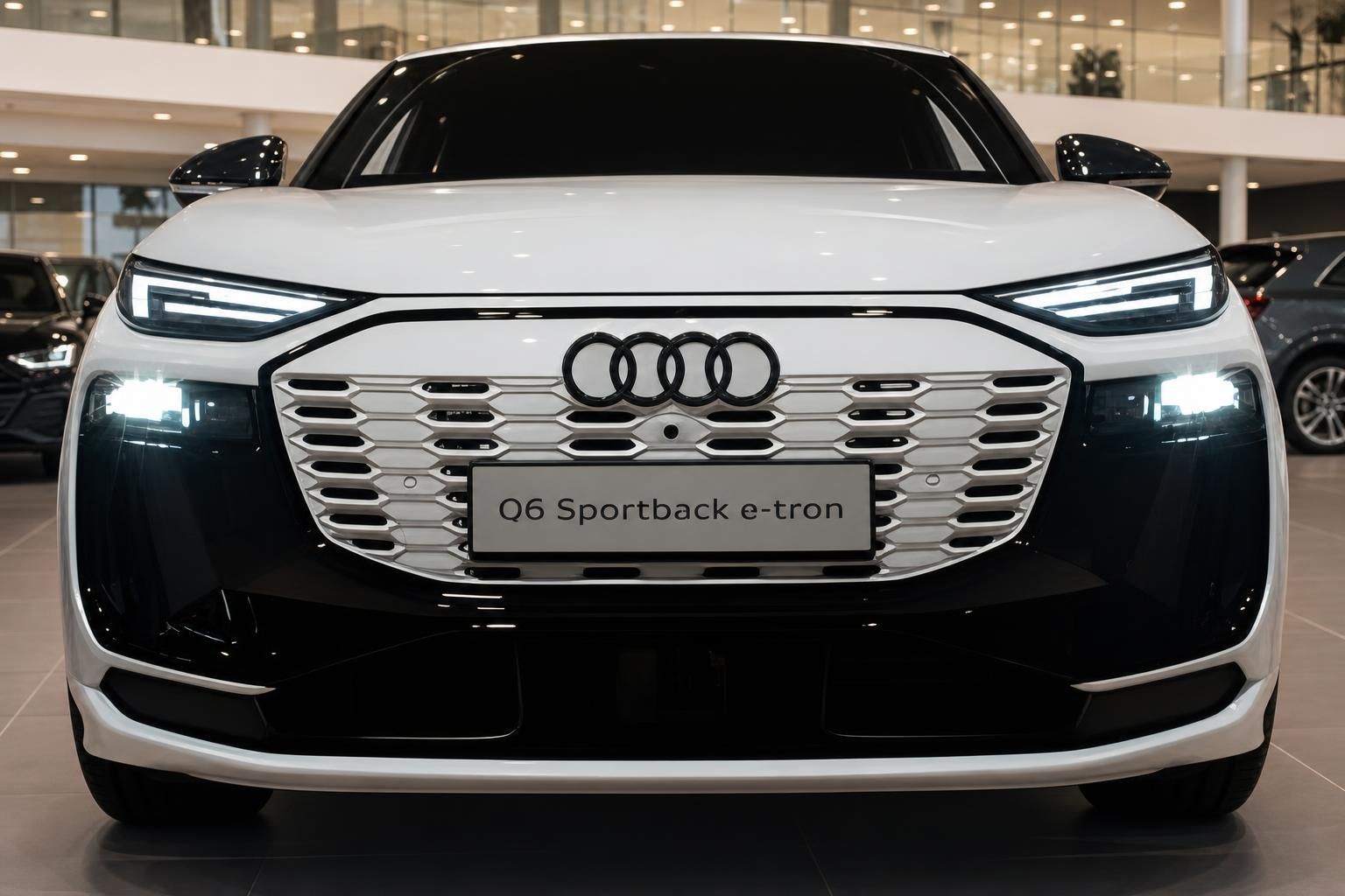 Audi Q6 Sportback e-tron weiß Frontansicht mit LED-Scheinwerfern im Autohaus