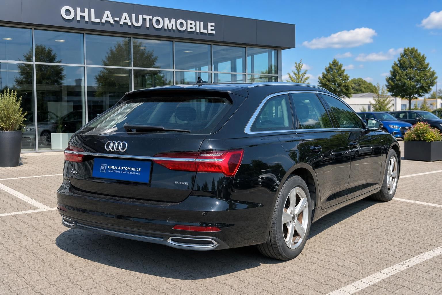 Audi A6 Avant schwarz Heckansicht auf Hof des Autohauses